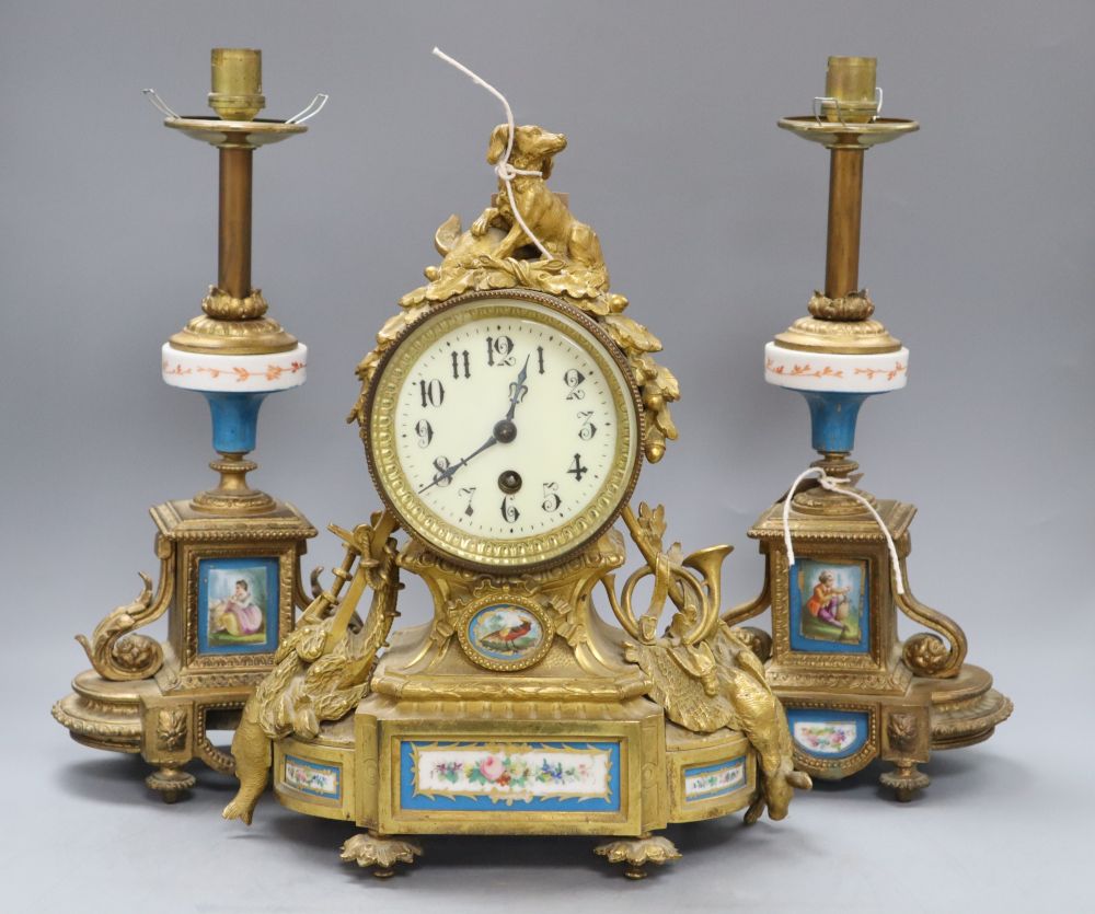 A 19th century French Louis XVI style ormolu mantel clock and a pair of associated spelter table lamps,